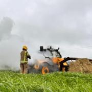 Firefighters tackle the burning telehandler