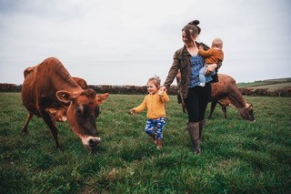 Katie with her young daughters checking on their herd of Jersey cows