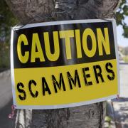 'Scammers' sign tied to tree