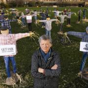 Riverford founder Guy Singh-Watson in front of 49 scarecrows outside the Houses of Parliament in London.
