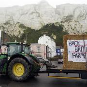 Farmers using their vehicles to protest against cheap meat imports drive past the Port of Dover in Kent.
